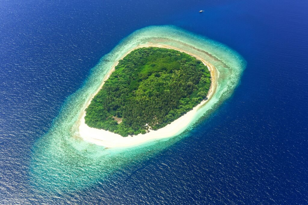 Explore the stunning tropical island surrounded by turquoise waters in this aerial photograph.